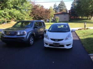 A gray Honda Pilot and a white Honda Fit.