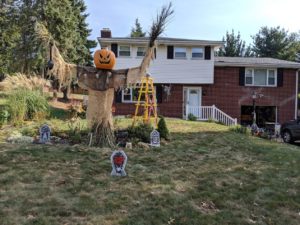 Halloween decorations including a giant scarecrow and headstones.