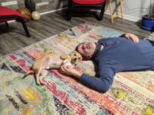 Arthur chi-mix and Gabe hanging out on the rug, looking into the camera.