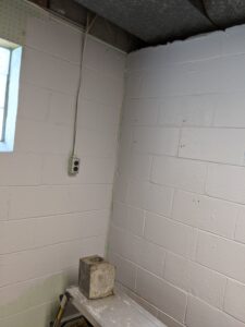 Our laundry room walls painted gray. There's a piece of the block wall sitting on a step ladder thing. It came out of the ceiling next to the duct work. *We did put it back!