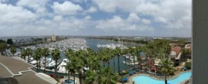 Panoramic photo of the outside of the hotel and the marina and the pool. Palm trees and water!