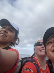 A selfie of Lucy, me and Renee. Our faces are all cut off a bit because of the angle. The sky is mostly cloudy.