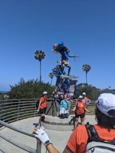 The Cardiff Kook. It's a tall pedestal with a beginner surfer dude on top of it. It's decorated for Rhett's birthday with blue streamers and a sign.