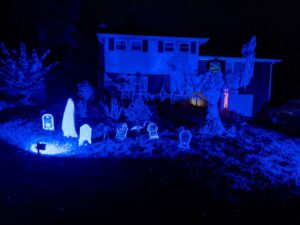 Nightime Halloween - everything is lit by black lights. It's the scarecrow, headstones, and the creepy white lady that's about 3 feet tall.