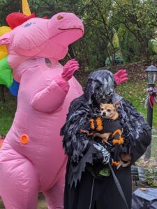 Gabe dressed as a giant pink unicorn, I'm dressed as a ghoul. I'm holding Arthur dressed as a spider.