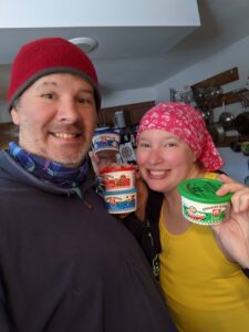 Gabe and Amand a holding AE Dips from Iowa. He's in a red beanie and a dark-colored pullover and she's in a pink patterned buff on her head - like a beanie - and a yellow shirt. Smiles all around!