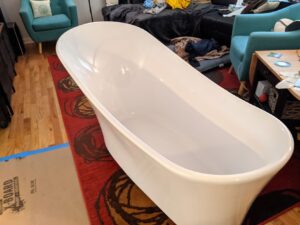 A free standing bathtub sitting in the living room of our house.