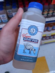 A small bottle that's like juice but says "Vegan Goat Pus'. This is as Omega Mart in Meow Wolf.