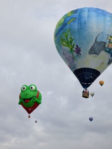 Two balloons. One makes me crack up - it's a frog wearing red overalls and it has its hands (yes, hands) up by its face and it looks really surprised. Its eyes are on top of the balloon and are huge and wide. The other balloon is an underwater seascape with fish and sting rays on it.