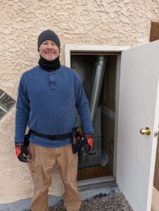 Gabe standing in front of the short door to the upstairs furnace. This house has some weird stuff for sure...