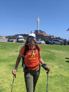 Lucy during the Athena walk standing on the top of Mount Soledad in front of the giant cross.